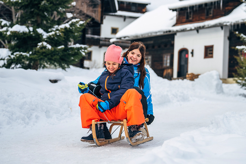 Schlittenfahren im familienfreundlichen Slow Travel Resort Kirchleitn in Bad Kleinkirchheim Kärnten, Winterurlaub mit Kindern.