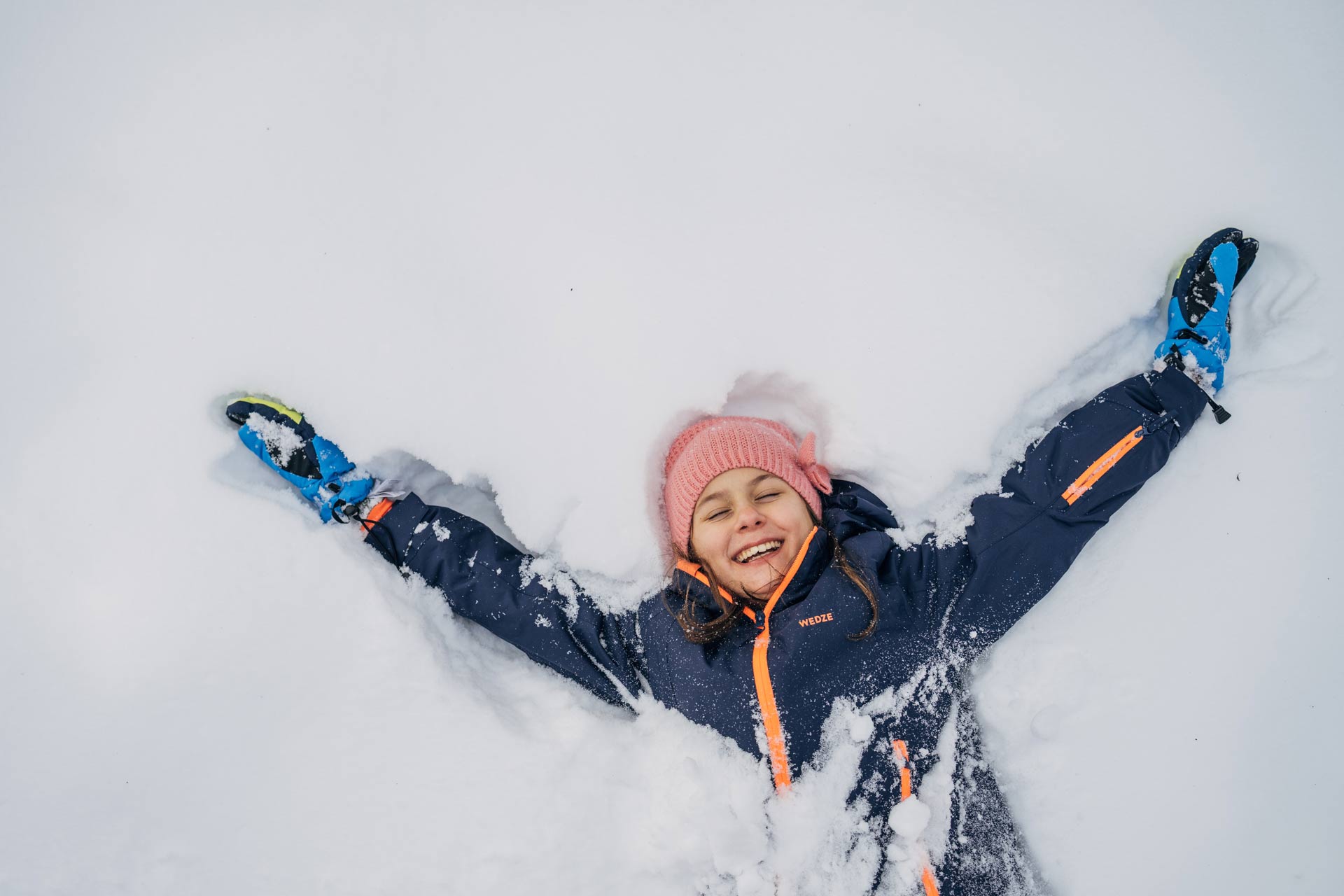 Kind macht Schneeengel in St. Oswald - Bad Kleinkirchheim Kärnten, Winterurlaub in den Bergen.